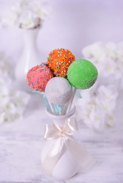 Söta cake pops i vas på bordet på ljus bakgrund — Stockfoto