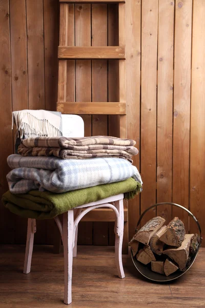 Теплі пледи на стільці на сільському дерев'яному фоні — стокове фото