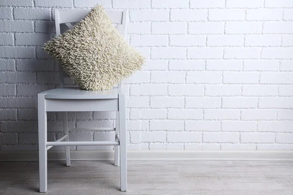Modern iç sandalye ve yastık üzerinde beyaz tuğla duvar arka plan — Stok fotoğraf