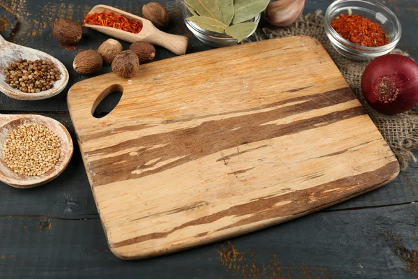 Různé koření a byliny s prkénko na dřevěný stůl barvy pozadí — Stock fotografie