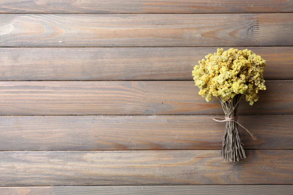 Bouquet of dried flowers on wooden planks background