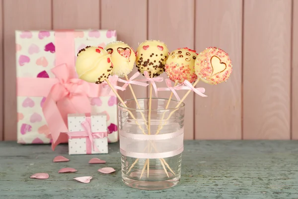 Tasty cake pops and gifts on wooden background — Stock Photo, Image