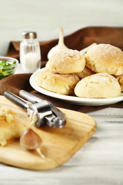 Čerstvý domácí chléb buchty z kynutého těsta na dřevěné prkénko, na barevné dřevěné pozadí — Stock fotografie