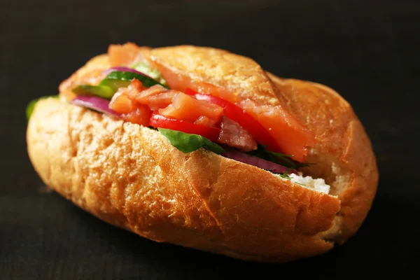 Sandwich con salmón sobre fondo de madera oscura — Foto de Stock