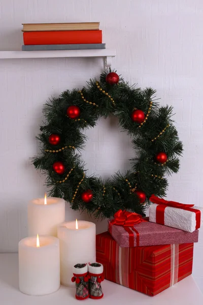 Christmas decoration with wreath on shelf on white wall background — Stock Photo, Image