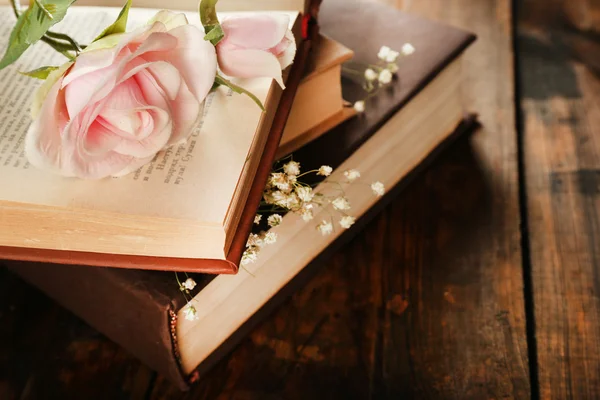 Boeken met bloemen op houten achtergrond — Stockfoto