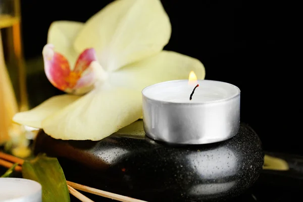 Bella composizione spa con candela e orchidea su sfondo scuro — Foto Stock