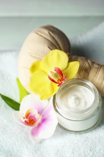 Wellness-Behandlungen mit Orchideenblüten auf Handtuch auf hölzernem Hintergrund — Stockfoto