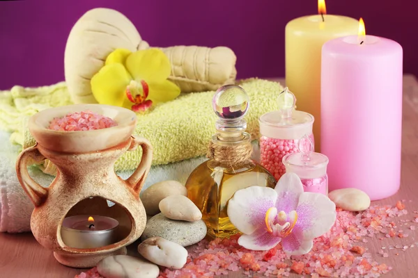 Wellness-Behandlungen mit Orchideenblume auf Holztisch vor buntem Hintergrund — Stockfoto