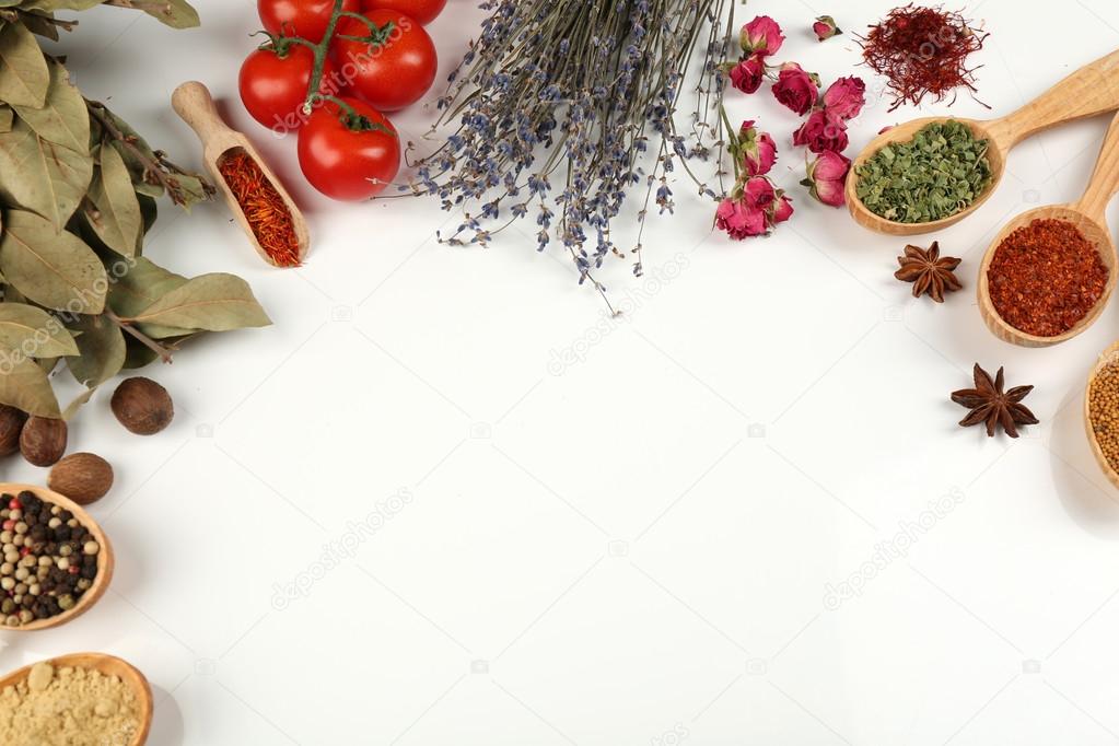 Different spices and herbs in wooden spoons isolated on white