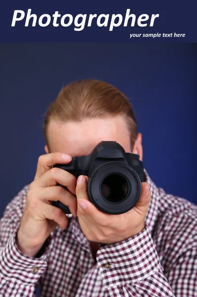Schöner Fotograf mit Kamera, auf dunklem Hintergrund — Stockfoto