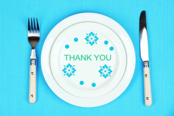 Teller mit Text Danke, Gabel und Messer auf Tischdecken Hintergrund — Stockfoto