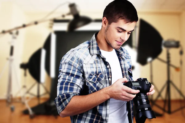 Handsome photographer with camera in photo studio — Stock Photo, Image