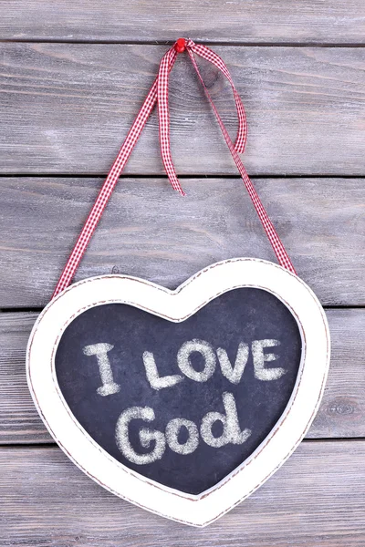 Kalp şeklinde chalkboard ve ahşap arka plan üzerinde Tanrı'nın metin seviyorum — Stok fotoğraf