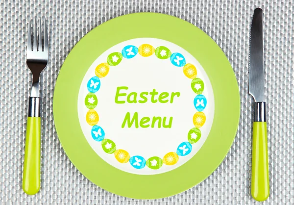 Teller mit Text "Ostermenü", Gabel und Messer auf grauem Hintergrund — Stockfoto