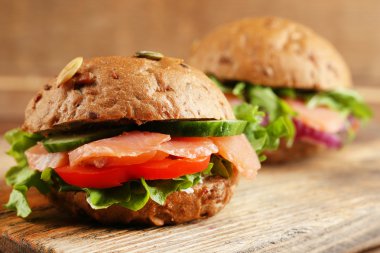 Sandviç somon ahşap arka plan üzerinde kesme tahtası üzerinde