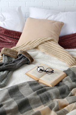 Kitap ve yatakta gözlük