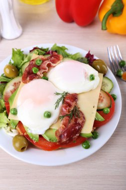 Haşlanmış yumurta, pastırma ve ahşap arka plan üzerinde tabakta sebze ile sandviç