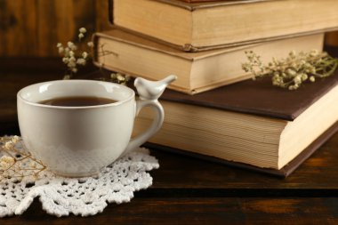 Ahşap arka plan kitapları ile çay