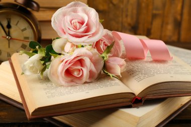 Ahşap zemin üzerine çiçek ve saat ile kitaplar