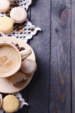 Yumuşak renkli kurabiye ve kahve kupa ahşap masa arka plan üzerinde