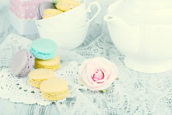 Macaroons on napkin and in cup on wooden table close-up — Stock Photo, Image