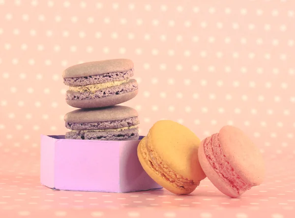 Macaroons saborosos em fundo de bolinhas rosa — Fotografia de Stock