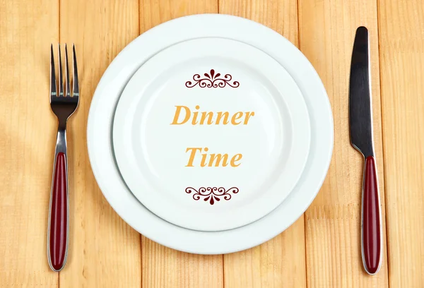 Placa con texto "Hora de la cena", tenedor y cuchillo sobre fondo de madera —  Fotos de Stock