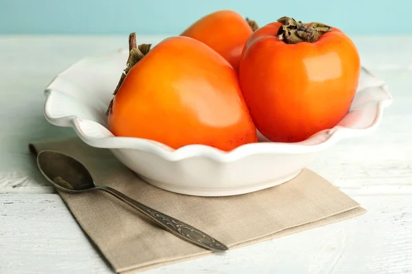 Ripe sweet persimmons, on wooden table — Stock Photo, Image