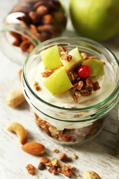 Postre en capas saludables con muesli y frutas en la mesa —  Fotos de Stock