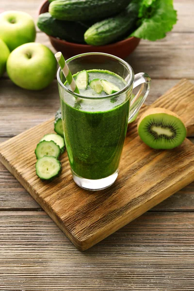 Grüner frischer gesunder Saft mit Obst und Gemüse auf Schneidebrett und Holztischhintergrund — Stockfoto