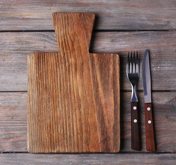 Cutting board with fork and knife — Stock Photo, Image