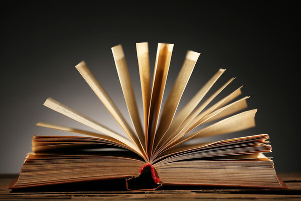 Open book over dark colorful background