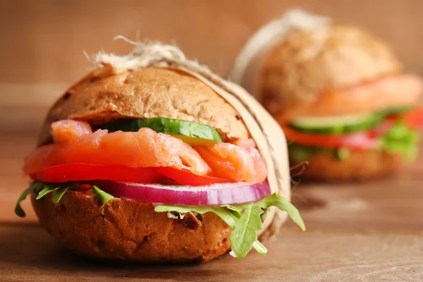 Sandwiches con salmón sobre fondo de madera — Foto de Stock