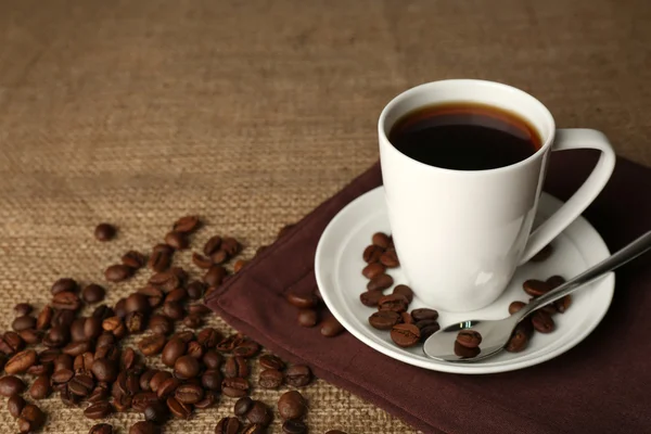 Cup of coffee with beans on rustic wooden background — Stock Photo, Image