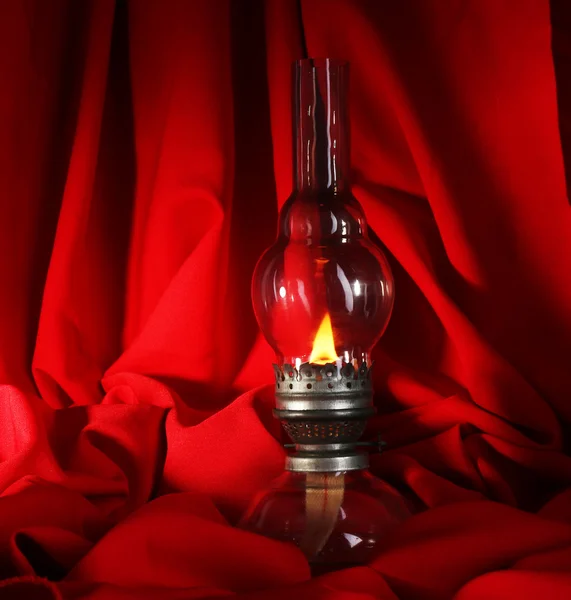 Kerosene lamp on red — Stock Photo, Image