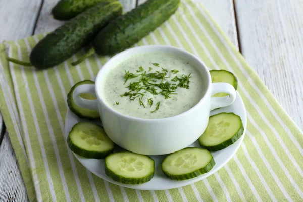 Cucumber soup in bowl on color wooden table background — Stock Photo, Image