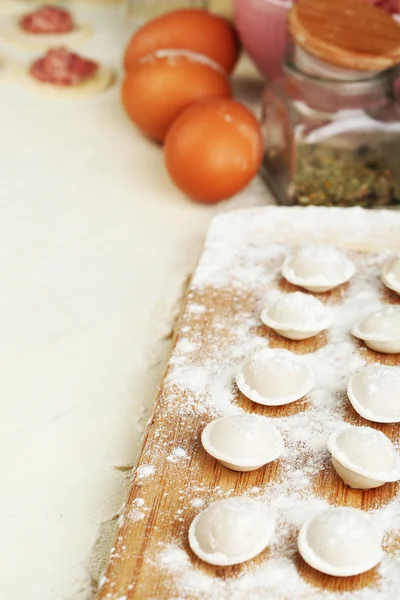 Raw dumplings on cutting board on table close-up — Stock Photo, Image