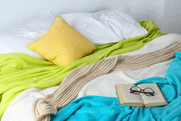 Book and glasses on bed — Stock Photo, Image