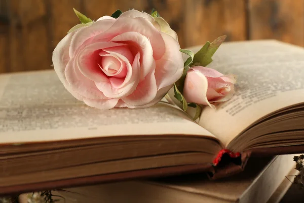 Books with flowers on wooden background — Stock Photo, Image