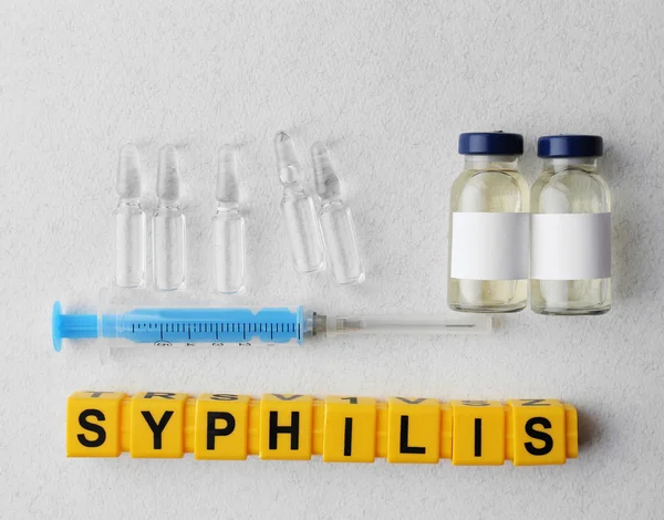Palabra de sífilis y equipo médico sobre fondo claro — Foto de Stock