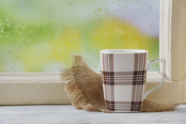 Cup of hot drink on windowsill — Stock Photo, Image