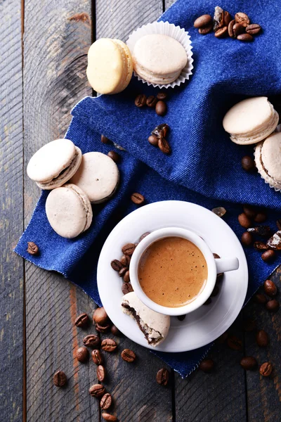 Makaroni yang lembut dan berwarna-warni dan kopi dalam cangkir di atas meja kayu latar belakang, tampilan atas — Stok Foto