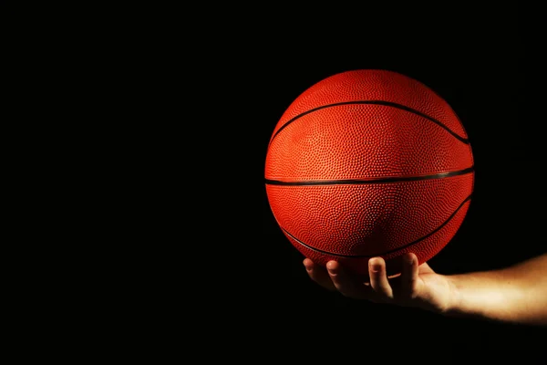 Basketball player holding ball, on dark background — Stock Photo, Image