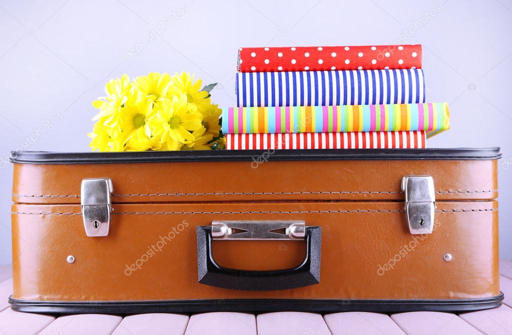 Vintage suitcase with pile on books