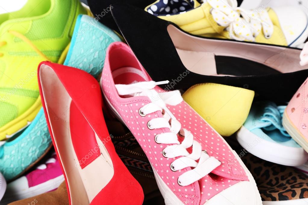 Many various female shoes close-up background