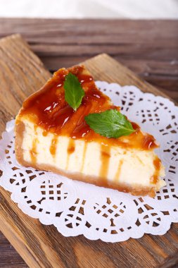 Peynir pasta kesme tahtası üzerinde açık renkli ahşap masa üzerinde kağıt peçeteye üzerinde