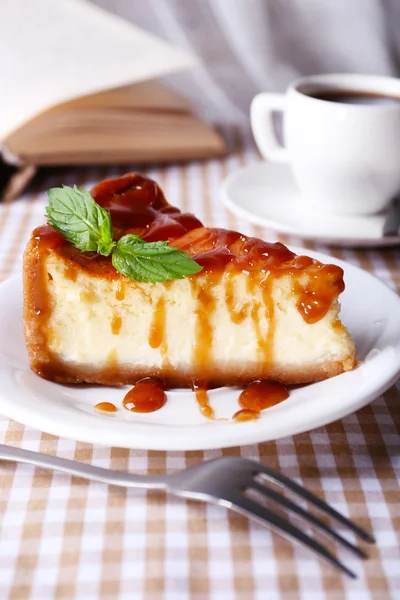 Gâteau au fromage et tasse de café sur la nappe sur fond de rideau — Photo