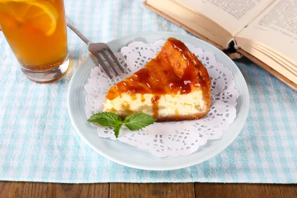 Bolo de queijo em prato, xícara de chá de ervas e livros em toalha de mesa — Fotografia de Stock