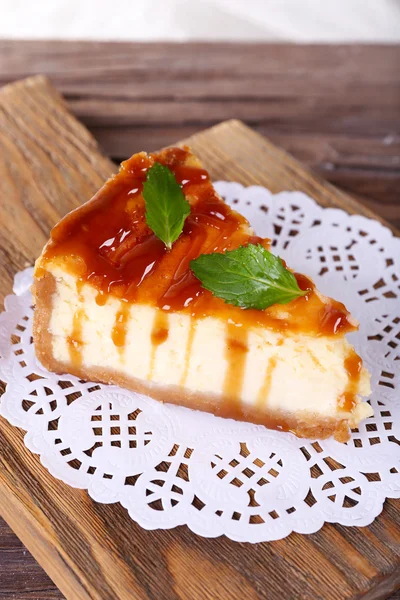 Torta di formaggio su tovagliolo di carta su tagliere su tavolo di legno su sfondo chiaro — Foto Stock